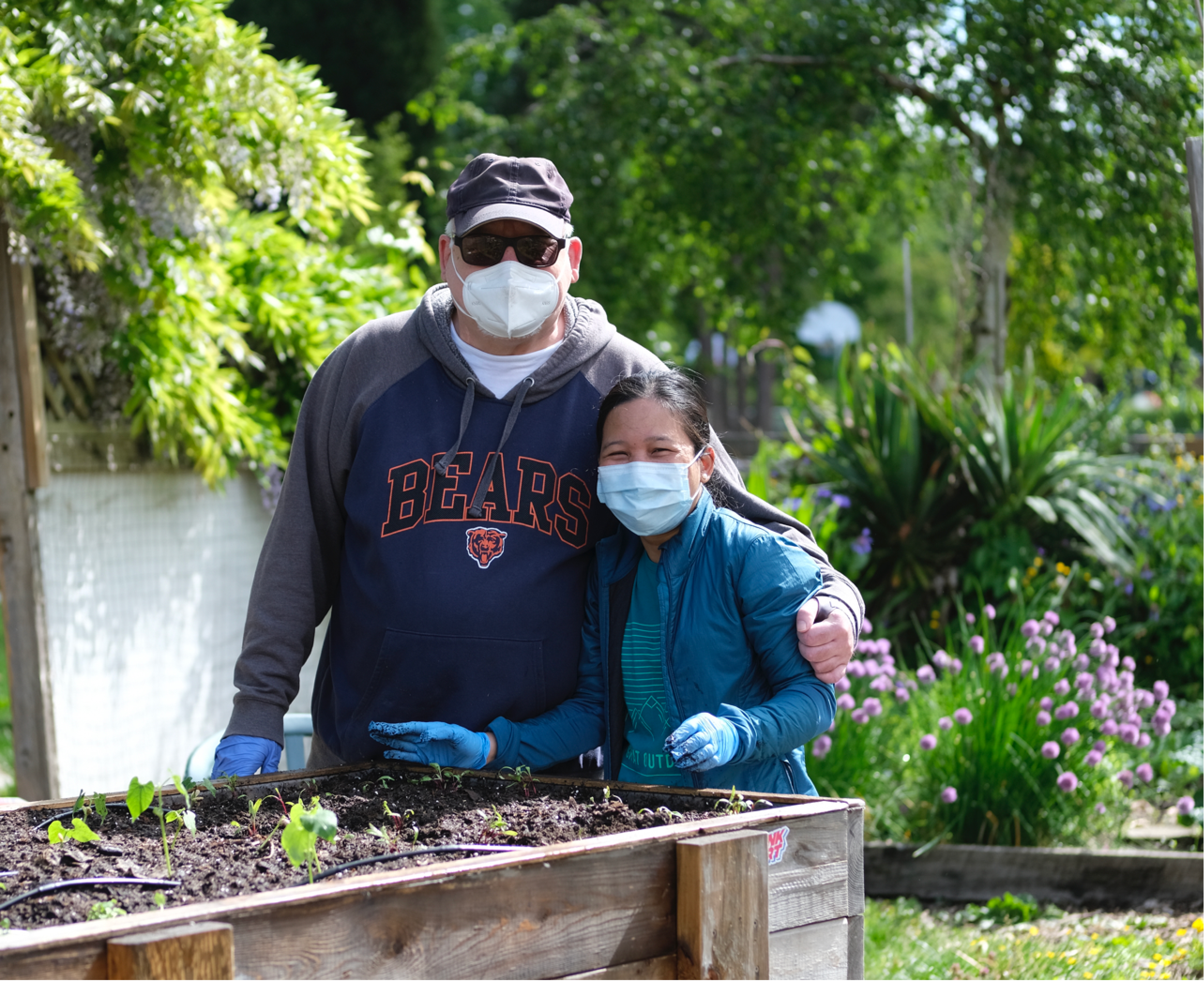 Board members Joseph Morrisette helping volunteer in garden.