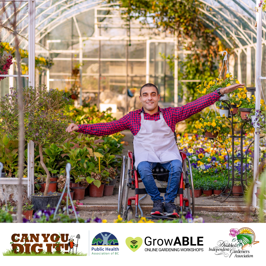 Individual in a wheelchair sitting with their hands outstretched in front of a greenhouse filled with plants.